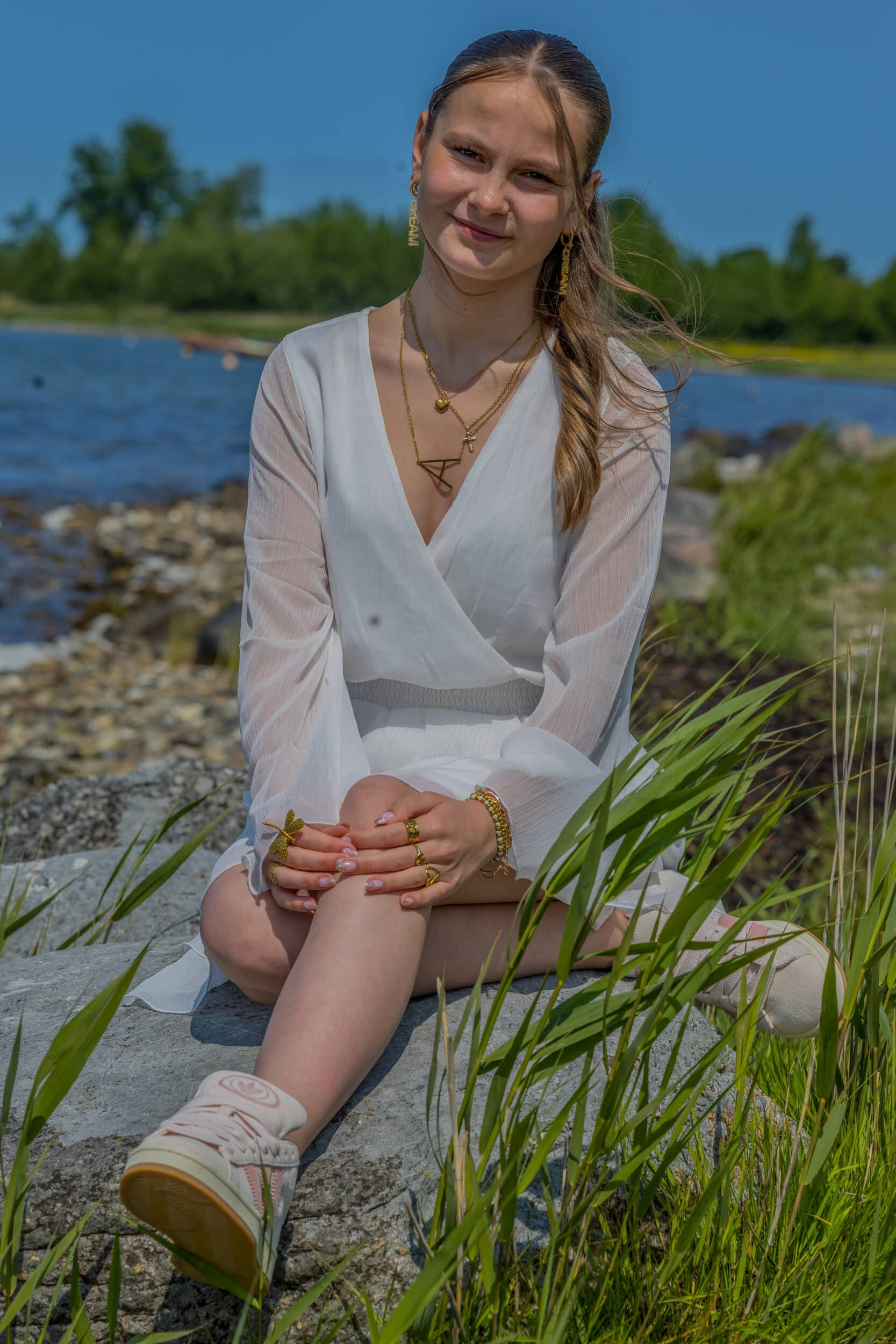 Siddende konfirmand ved havet scaled Konfirmation